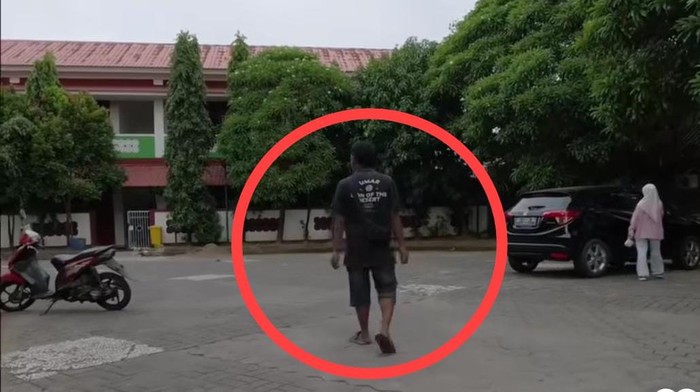 Jukir liar membuntuti pengendara meminta biaya parkir saat hendak meninggalkan Masjid Cheng Hoo Makassar.