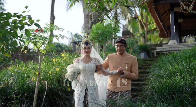 Luna tampil cantik manglingi kenakan kebaya putih dengan potongan leher berbentuk semi v-neck dipadukan kain batik berwarna putih-coklat khas Yogyakarta. Kebaya tersebut tampak elegan dengan detail bordir dan siluet pas badan. Foto: YouTube/Luna Maya