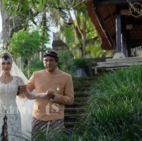 Luna tampil cantik manglingi kenakan kebaya putih dengan potongan leher berbentuk semi v-neck dipadukan kain batik berwarna putih-coklat khas Yogyakarta. Kebaya tersebut tampak elegan dengan detail bordir dan siluet pas badan. Foto: YouTube/Luna Maya