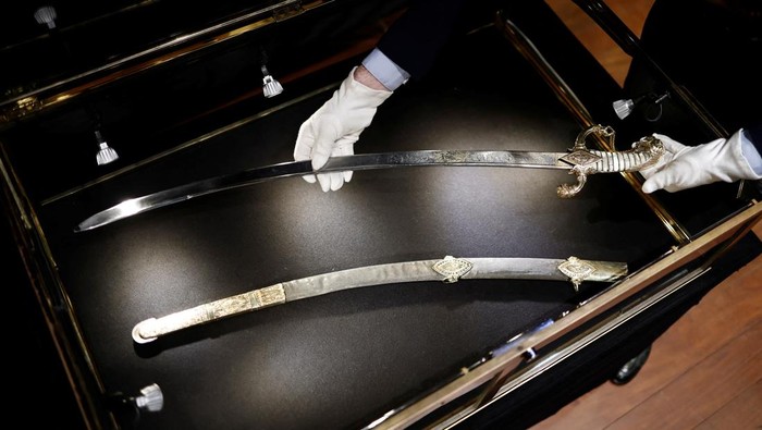 A Drouot employee holds the saber that Napoleon ordered for his personal use from the arquebusier Nicolas-Noel Boutet in 1802 before its auction at Drouot auction house in Paris, France, April 24, 2025. REUTERS/Benoit Tessier     TPX IMAGES OF THE DAY