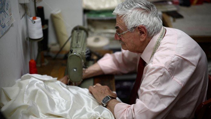 Potret Penjahit Vatikan Siapkan Jubah untuk Paus Terpilih Clerical robe tailor Raniero Mancinelli works on one of the three white Pope cassocks he made, to be delivered to the Vatican, at Mancinelli's liturgical vestments shop near the Vatican, in Rome, Italy, May 6, 2025. REUTERS/Guglielmo Mangiapane
