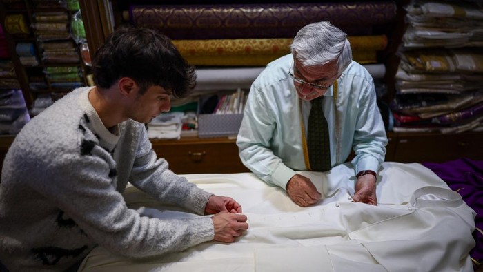 Potret Penjahit Vatikan Siapkan Jubah untuk Paus Terpilih Clerical robe tailor Raniero Mancinelli works on one of the three white Pope cassocks he made, to be delivered to the Vatican, at Mancinelli's liturgical vestments shop near the Vatican, in Rome, Italy, May 6, 2025. REUTERS/Guglielmo Mangiapane