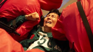 Gi Hun (Lee Jung Jae) ditawan para tentara pink. Tampak darah dan bekas luka di pelipisnya.