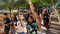 Dengan spanduk dan seruan perlindungan tanah leluhur, pendukung San Carlos Apache memprotes rencana penambangan di wilayah Oak Flat.  
