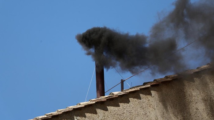 Black smoke rises from the chimney on the Sistine Chapel, indicating no decision has been made to elect a new pope, at the Vatican, May 8, 2025. REUTERS/Yara Nardi