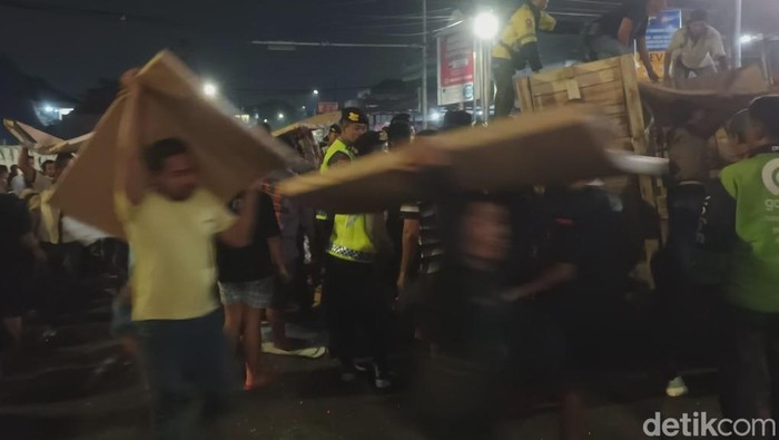 Warga turut membantu mengangkat tumpukan kertas untuk diletakan ditepi jalan.