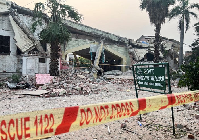 Police officers look on as a cameraman films the Bilal Mosque, after it was hit by an Indian strike in Muzaffarabad, the capital of Pakistan-administered Kashmir, May 7, 2025. REUTERS/Akhtar Soomro