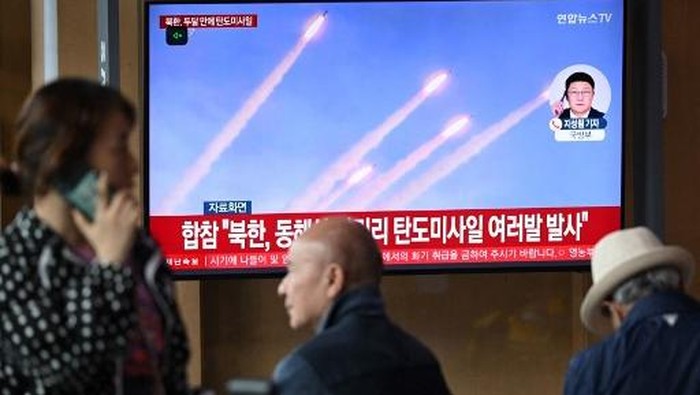People watch a television screen showing a news broadcast with file footage of a North Korean missile test, at a train station in Seoul on May 8, 2025. North Korea fired what appeared to be multiple short-range ballistic missiles on May 8, South Koreas military said, around a week after leader Kim Jong Un tested a new weapons system for his latest warship. (Photo by Jung Yeon-je / AFP)