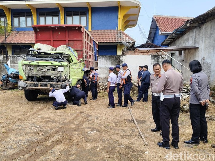 Petugas melakukan pemeriksaan truk dan angkot yang terlibat kecelakaan maut di Purworejo, Kamis (8/5/2025).