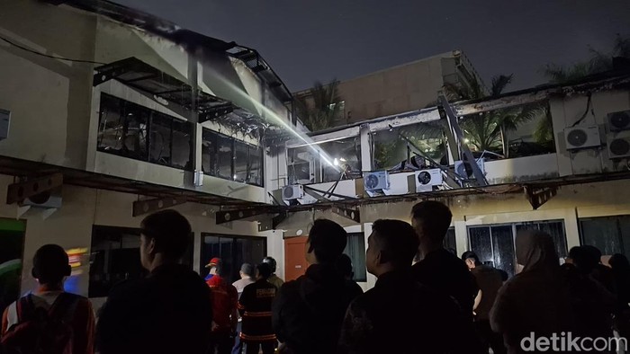 Petugas pemadam kebakaran melakukan pendinginan di gedung Lonsum Cabang Palembang yang terbakar.