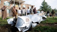 Warga berkerumun di sekitar puing logam di Wuyan, distrik Pulwama, Kashmir, Rabu (7/5/2025). (Sharafat Ali/Reuters)