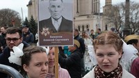 Warga Vladivostok membawa potret Tentara Merah dan veteran dalam Pawai Resimen Abadi untuk memperingati 80 tahun kemenangan Rusia atas Nazi Jerman di Vladivostok, Jumat (9/5/2025). (Tatiana Meel/Reuters) 