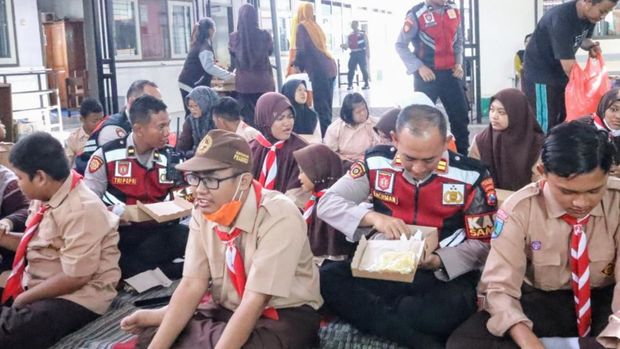 Anggota Satsamapta Polres Situbondo mengajak siswa SLB Dharma Wanita makan bersama. Para siswa tampak ceria.