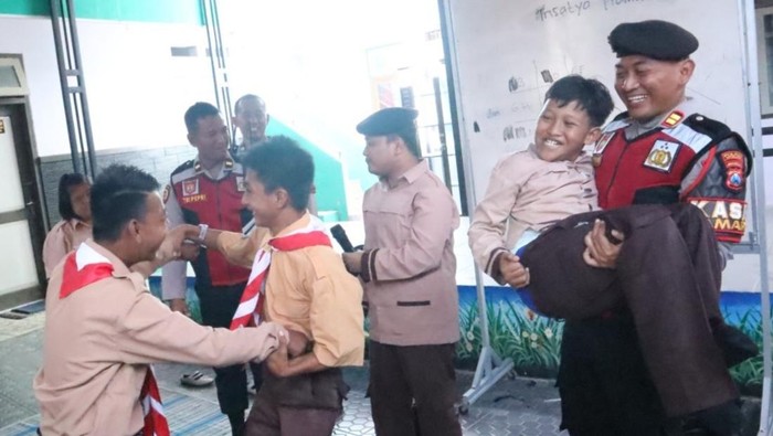 Anggota Satsamapta Polres Situbondo mengajak siswa SLB Dharma Wanita makan bersama. Para siswa tampak ceria.