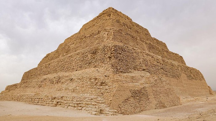 GIZA, EGYPT - MAY 4: Tourists ride on camels as Zoser Pyramid is seen behind at the historical Saqqara region, which is home to the majority of historical artifacts from ancient Egypt, in Giza, Egypt on May 4, 2025. King tombs, temples, small pyramids and the region, where the Zoser Pyramid, which is estimated to have been built in the 2700 B.C. is located, considered an open-air museum. (Photo by Nurettin Boydak/Anadolu via Getty Images)