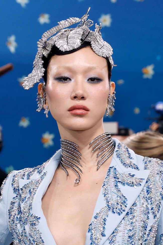 Model asal Korea Selatan, Sora Choi, tampil seperti kristal berjalan dalam balutan Swarovski dari ujung kepala hingga kaki. Jaket biru es dan rok berbulu dihiasi ikat pinggang kristal berbentuk bulu burung, yang selaras dengan hiasan kepala, anting, dan choker Swarovski-nya. (Foto: Taylor Hill/Getty Images)