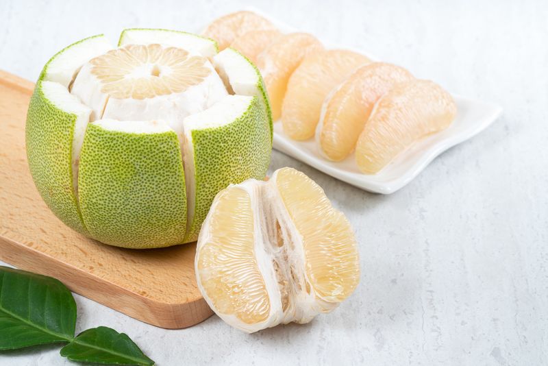 Ilustrasi jeruk bali atau pomelo Close up of fresh peeled pomelo on white table background for Mid-Autumn Festival fruit.