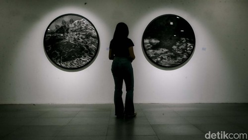 Sejumlah pengunjung tengah menyaksikan karya lukis di pameran Utopian Dreams: Dystopian World yang berlangsung di Neo Gallery, Jakarta, Jumat (9/5/2025).