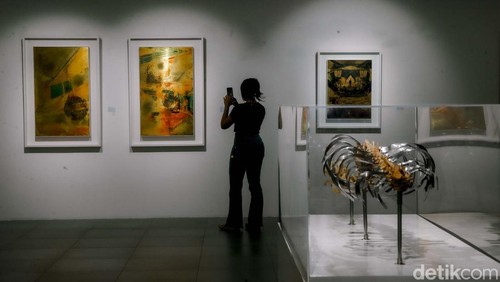 Sejumlah pengunjung tengah menyaksikan karya lukis di pameran Utopian Dreams: Dystopian World yang berlangsung di Neo Gallery, Jakarta, Jumat (9/5/2025).
