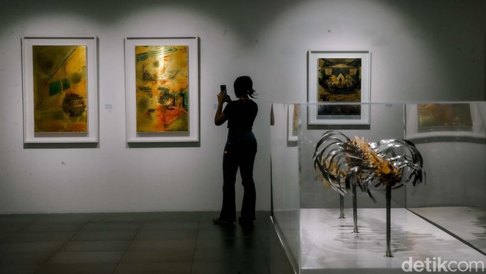 Sejumlah pengunjung tengah menyaksikan karya lukis di pameran Utopian Dreams: Dystopian World yang berlangsung di Neo Gallery, Jakarta, Jumat (9/5/2025).