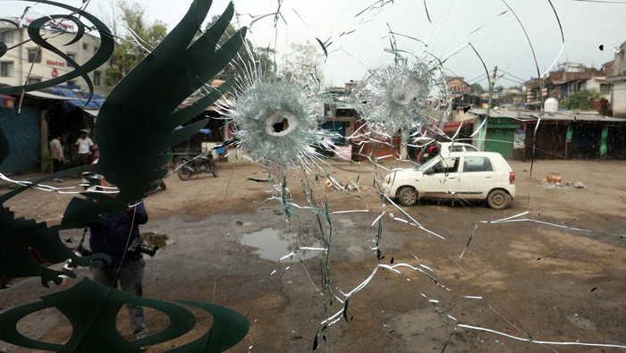 People are seen through the windshield of a bus damaged by a cross-border shelling in Poonch near the Line of Control (LoC) between India and Pakistan, May 8, 2025. REUTERS/Stringer