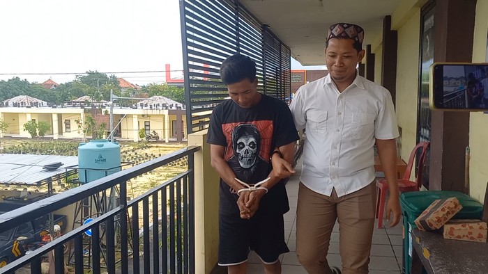 Pelaku penganiaya anak dan istrinya di Sampang saat dikeler ke kantor polisi setelah ditangkap