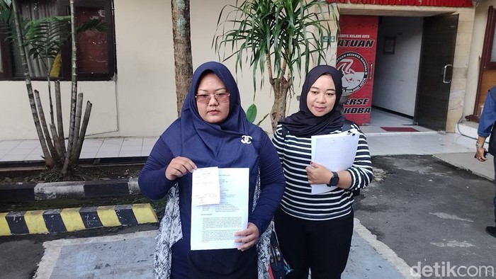 Maya (kiri) dan kerabatnya saat melapor ke Polresta Malang Kota