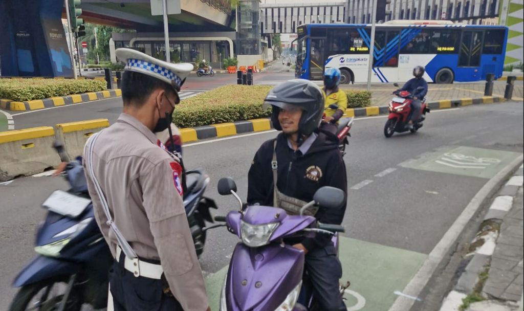 Seorang Polisi menindak seorang pengendara yang melanggar dengan tidak memasang plat nomor. (X/@TMCPoldaMetro)