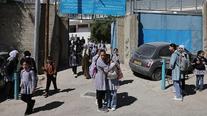 Palestinian schoolgirls leave a UNWRA school in the Shoafat refugee camp in east Jerusalem on May 8, 2025, as Israeli security forces reportedly prepare to close the school. (AFP)