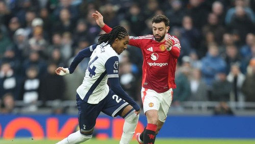 LONDON, ENGLAND - FEBRUARY 16: Tottenham Hotspurs Djed Spence and Manchester Uniteds Bruno Fernandes during the Premier League match between Tottenham Hotspur FC and Manchester United FC at Tottenham Hotspur Stadium on February 16, 2025 in London, England. (Photo by Rob Newell - CameraSport via Getty Images)