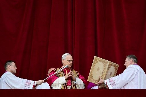 Paus Leo XIV, yang baru terpilih dari hasil Konklaf tanggal 7-8 Mei 2025, menyampaikan salam dan berkat pertamanya dari balkon Basilika Santo Petrus. 
(Photo by Tiziana FABI / AFP)