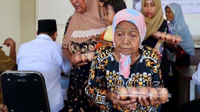 Warga rentan menerima telur ayam hasil peternakan di Desa Watukebo.