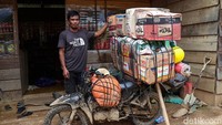 Muhammad Rapil (37) berdiri di dekat motornya yang mengangkut barang campuran saat tiba di rumahnya di Kecamatan Seko, Kabupaten Luwu Utara, Sulawesi Selatan.