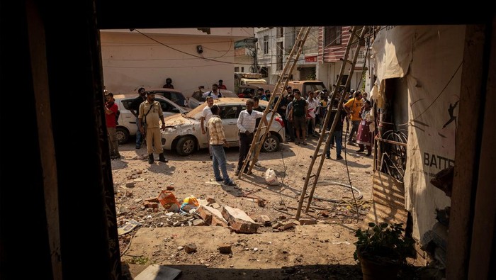 People stand next to a damaged vehicle in a neighbourhood, following Pakistan's military operation against India, in Rehari, Jammu, May 10, 2025. REUTERS/Adnan Abidi