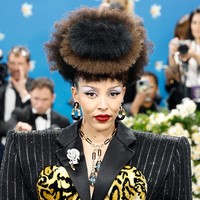 Doja Cat memadukan bodysuit rancangan Marc Jacobs dengan perhiasan dari David Webb. Ia mengenakan anting lingkar hitam-emas bertakhtakan berlian, kalung paper clip dengan aquamarine dan berlian, serta bros mawar berlian di kerah jas. Serangkaian cincin berlian dari rumah mode yang sama menyempurnakan tampilannya. (Foto: Taylor Hill/Getty Images)