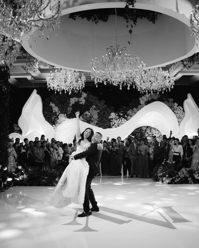 Pada saat resepsi pernikahan, Cellos masih memakai setelan jas dari Wonghang Tailor. Hanya saja kali ini dalam warna hitam. Sedangkan Natasha mengenakan gaun dengan potongan sweetheart neckline yang bertabur payet dan kristal rancangan Soko Wiyanto.  Foto: Dok. Instagram by.hilda