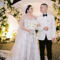 Cellos dan Natasha Putri tampil serasi mengenakan busana putih pada saat pemberkatan pernikahan. Cellos memakai jas dan dasi kupu-kupu dari Wonghang Tailor. Sedangkan Natasha mengenakan gaun rancangan Soko Wiyanto. Foto: Dok. Instagram by.hilda