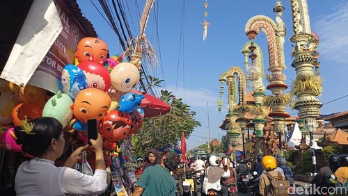 Puluhan penjor menjulang tinggi berdiri di depan Pura Petilan Kesiman, Denpasar, Bali. Penjor-penjor tersebut ditancapkan untuk menyambut ritus Ngerebong pada Minggu (11/5/2025). (Foto: Ni Made Lastri Karsiani Putri/detikBali)