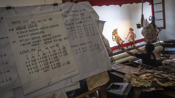 Seorang siswa didampingi pengajar memainkan alat musik gamelan saat latihan dalang cilik dan karawitan di Gedung Monod Diephius, kawasan Kota Lama, Semarang, Jawa Tengah, Minggu (11/5/2025). Pelatihan yang diikuti oleh anak-anak dari perkumpulan karawitan dan pedalangan Monod Laras yang diselenggarakan setiap hari Minggu itu bertujuan untuk melestarikan seni budaya Indonesia, khususnya di bidang wayang kulit dan gamelan. ANTARA FOTO/Aprillio Akbar/agr