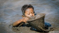 Mulai dari anak-anak hingga orang dewasa tampak antusias turun langsung ke kolam, berlomba-lomba menangkap ikan dengan tangan kosong, diiringi sorak sorai penonton di pinggir empang.