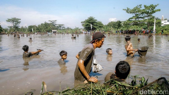 Serunya Melihat Kegiatan Ngubek Empang, Tradisi Betawi Depok Jelang Lebaran Ratusan warga tampak antusias mengikuti kegiatan Ngubek Empang yang digelar di kawasan Pengasinan, Depok, pada Minggu (11/5). Tradisi yang telah mengakar sejak zaman orang tua dahulu ini kembali diadakan sebagai bagian dari rangkaian acara Lebaran Depok 2025.