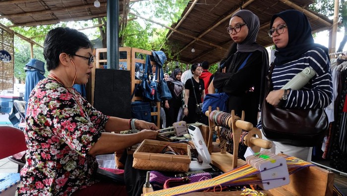 Pengunjung melihat produk kerajinan seni yang dipasarkan saat Solo Art Market di kawasan wisata Ngarsopuro Solo, Jawa Tengah, Minggu (11/5/2025). Pengelola pasar seni setempat menargetkan transaksi penjualan dari pameran produk 103 pelaku UMKM dan komunitas kreatif di Solo ini mencapai Rp60 juta pada momen liburan panjang Waisak dan cuti bersama. ANTARAFOTO/Maulana Surya