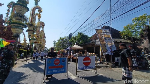Beberapa pecalang saat bertugas mengalihkan lalin di seputaran Jalan WR Supratman Denpasar, Minggu (11/5/2025).