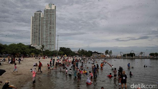 Pengunjung menikmati suasana Pantai Ancol, Jakarta Utara, Senin (12/2025).