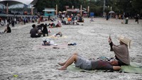 Pengunjung menikmati suasana Pantai Ancol, Jakarta Utara, Senin (12/2025).