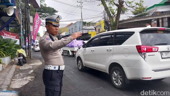 Petugas melakukan pengaturan arus lalu lintas di simpang empat pendem, Kota Batu.