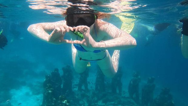 Seorang turis menyelam di patung sepasang kekasih di Perairan Gili Meno, Lombok Utara, NTB, Sabtu (26/4/2025).