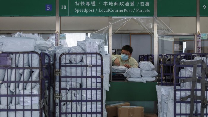 A postal worker processes parcels at a post office as Hong Kong Post restricts U.S.-bound shipments due to new U.S. tariff rules, in Hong Kong, China, May 2, 2025. REUTERS/Tyrone Siu