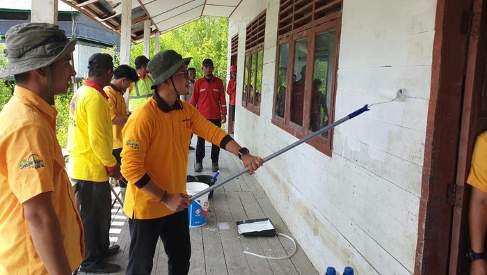 Karyawan BAP Distrik Tanjung Jati mengecat dinding dan ruang kelas SD Filial Dusun V Sungai Janun, OKI.