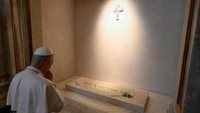 Dengan mengenakan jubah putih, Paus Leo berlutut dan berdoa di depan makam marmer Paus Fransiskus, yang wafat pada 21 April lalu. 